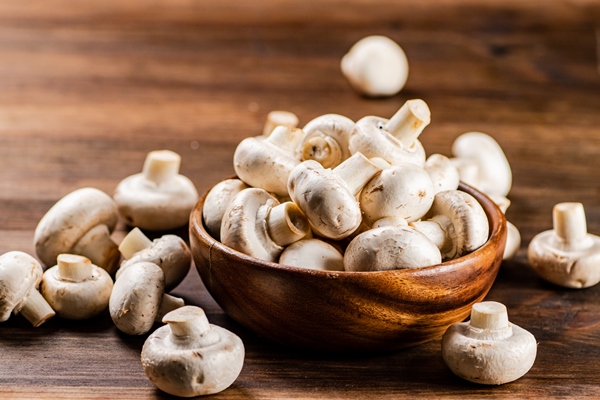 a wooden plate full of fresh mushrooms - Заливное из шампиньонов