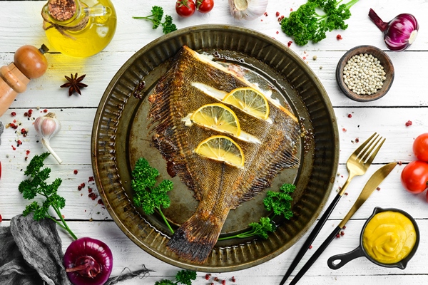 baked flounder fish with lemon and spices on a metal baking dish seafood top view free space for - Как правильно обрабатывать и готовить рыбу?