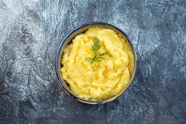 close up view of mashed potatoes served with dill on dark color background with free space - Постные картофельные зразы