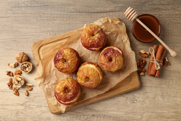 concept of tasty food with baked apple on wooden background - Фрукты, ягоды