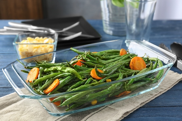 delicious green beans and carrot slices in glass baking dish on table - Запеканки в духовке: правила приготовления