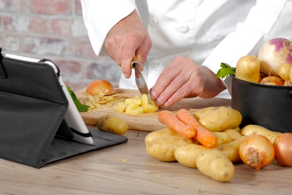 detail of hands of chef slicing potatoes - Лососевая уха из обрезков