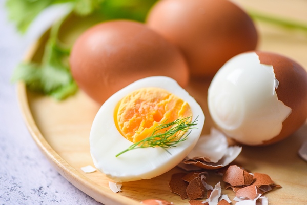 eggs breakfast fresh peeled eggs menu food boiled eggs in a wooden plate decorated with leaves green dill and eggshell cut in half egg yolks for cooking healthy eating - Заливной пирог с зелёным луком и яйцом