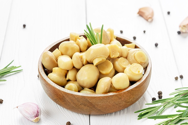 fermented food canned champignons in a wooden bowl on a white wooden table - Салат «Мазурка»