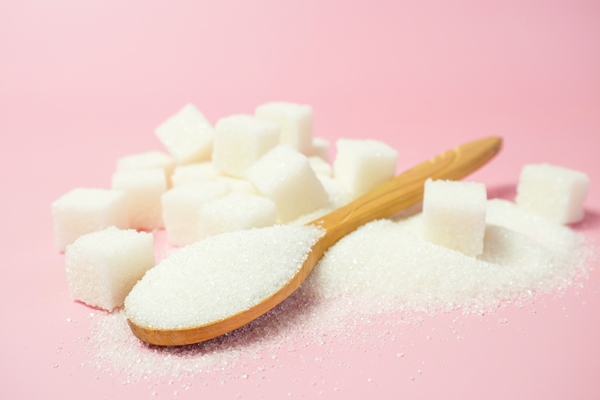granulated sugar and sugar cubes on a pink background with space for - Клюквенный зефир