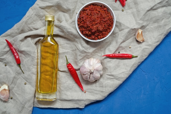 harissa ingredients for cooking hot chilli red pepper coarse sea salt garlic cumin zira olive oil ground coriander on a dark slate table adjika muhammara eastern cuisine - Аджика с яблоками