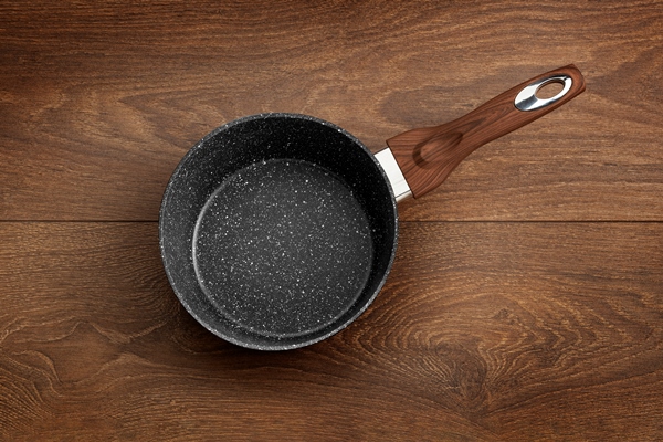 modern frying pan with nonstick granite coating isolated on a wooden surface background - Гречневые постные хлебцы