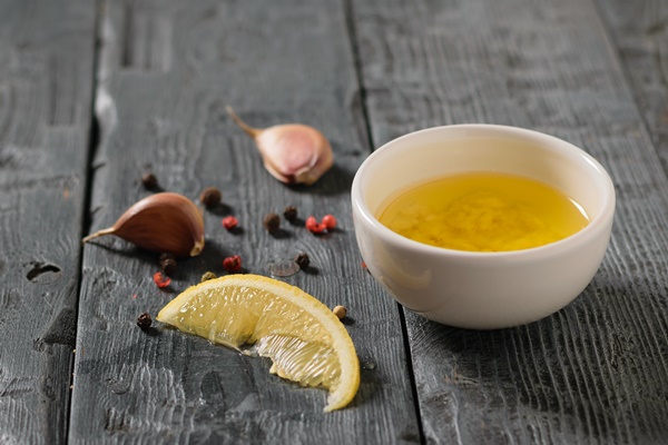 olive oil with garlic and lemon in a white bowl on a village table dressing for diet salad - Салат «Мазурка»