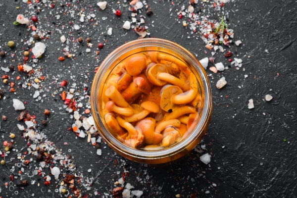 pickled mushrooms in a glass jar food stocks top view - Жареные опята на зиму