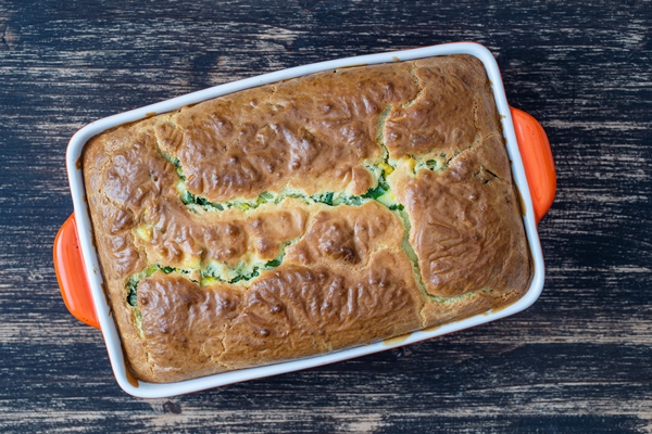 pouring pie with green wild garlic leaves and boiled eggs on wooden table close up top view - Заливной пирог с зелёным луком и яйцом