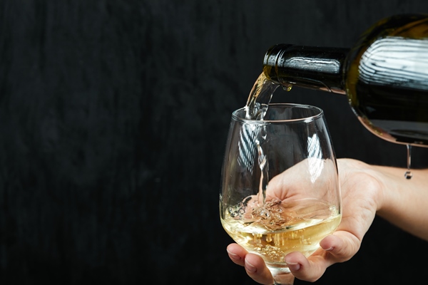 pouring white wine into the wine glass on dark surface - Маленькие хитрости приготовления пищи