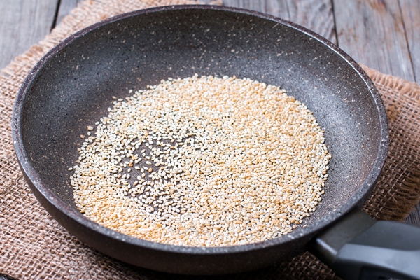 sesame seeds are fried in the pan - Салат с киви и пекинской капустой