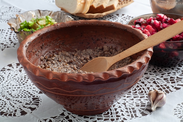 there is a kutia and a wooden spoon on the table in a jug ukrainian food - Сочиво