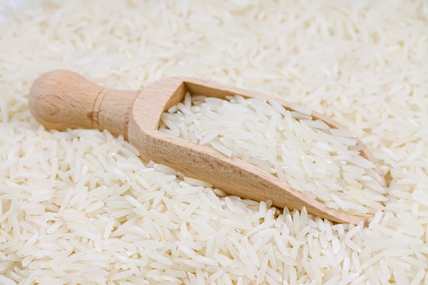 uncooked long grain rice in a wooden spoon - Крупяные и макаронные изделия: полезные советы