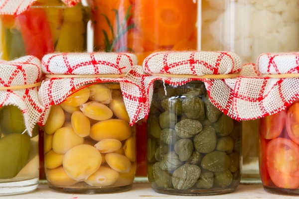 variety of jars with organic vegetable pickles - Острый маринованный чеснок