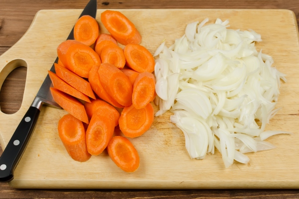 variously sliced for cooking carrots and onions on a cutting board - Лососевая уха из обрезков