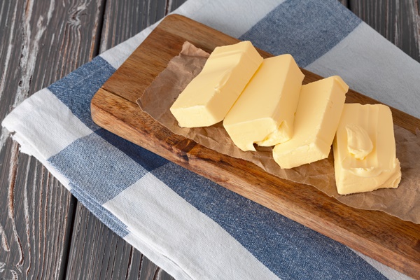 wooden board with butter on blue checkered napkin - Заливной пирог с зелёным луком и яйцом