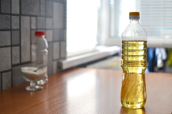 a bottle of vegetable oil on the table in the kitchen is - Салат из перца, зелёного горошка и риса