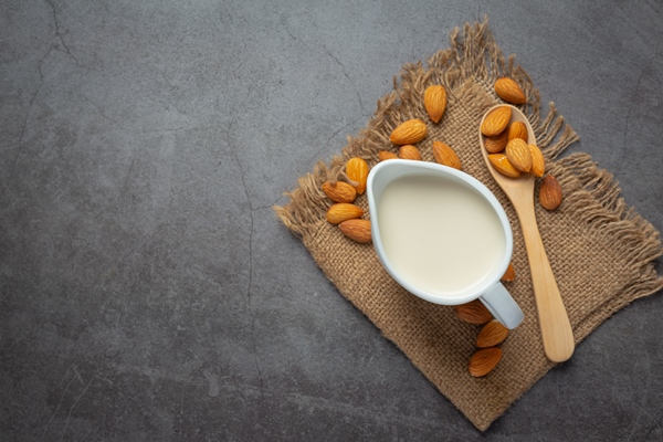 almond milk with almond on dark background - Соевые блины на миндальном молоке