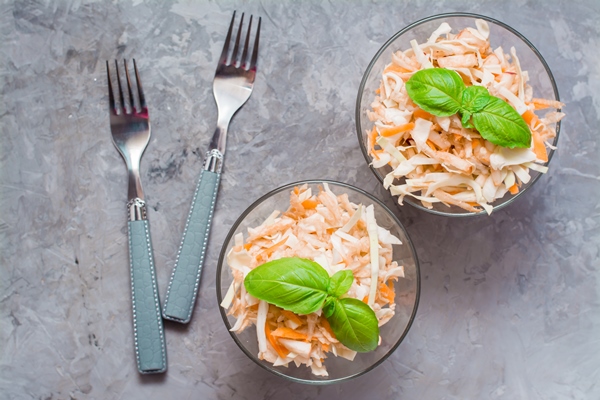 american ready to eat cole slaw salad of cabbage celery carrots and apples with basil leaves in glass bowls in the ingredients for cooking on the table the concept of healthy and proper nutrition - Салат из клюквы