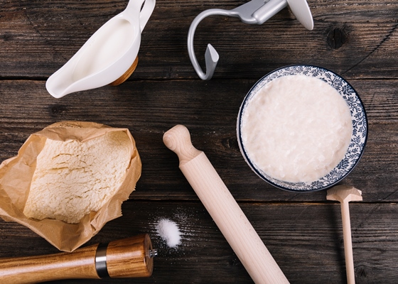 an overhead view of flour milk yeast and peppermill with rolling pin on table - Баба муслиновая