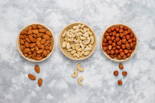 assortment of nuts in ceramic plates cashew hazelnuts walnuts pistachio pecans pine nuts peanut raisins top view - Пасхальный венок