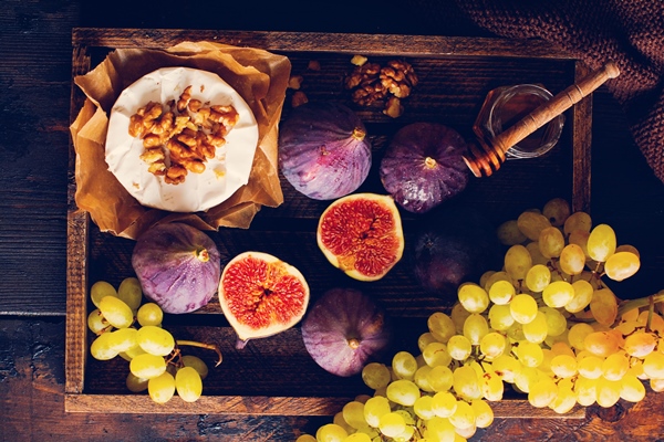 camembert cheese with figs walnuts honey and thyme served for a dinner in dark key on wooden surface in retro style - Библия о пище