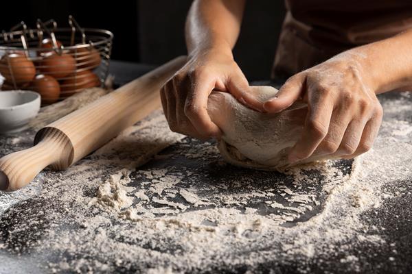 chef kneading the dough in flour on the table - Кулич (пасха) подольский старинный