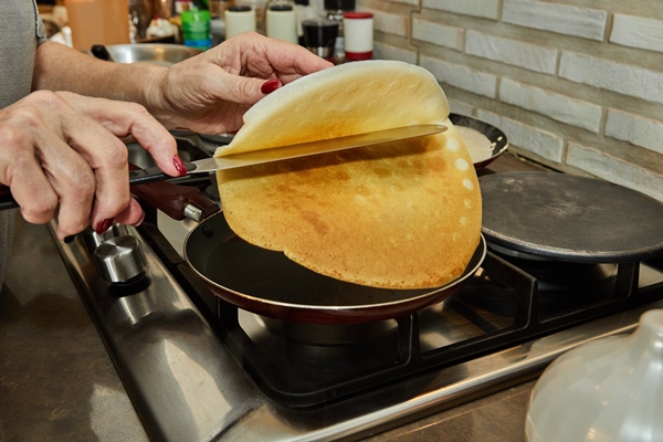 chef panfrying crepe suzette pancakes with cognac and citrus sauce - Постные дрожжевые блины «Гречишники»