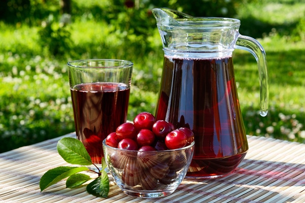 cherry juice in a glass and carafe with cherries on natural background - Мороженое из вишен или красной смородины