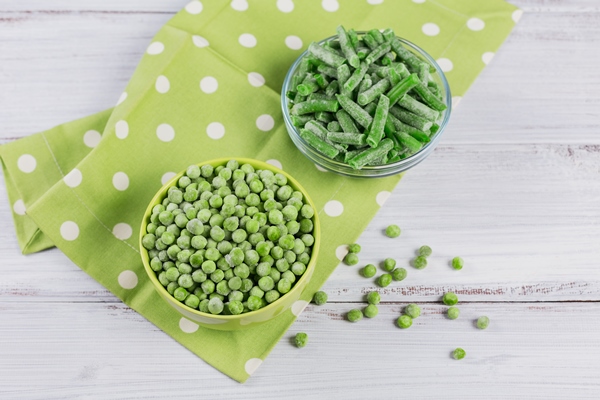 composition with different organic frozen vegetables on white wooden background green beans and peas in a bowl - Салат рыбный