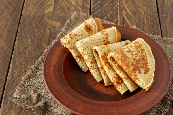 crepes or russian blini on wooden backgroundin rustic style homemade thin crepes for breakfast or dessert - Русские гречневые дрожжевые блины