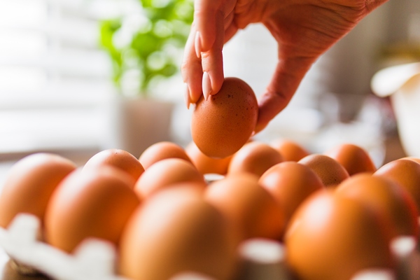 crop hand taking eggs from carton - Пасхальный каравай "Касатьелло"