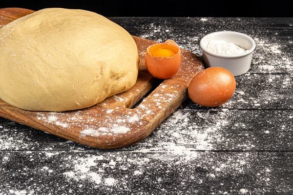 dough preparation yeast dough for pies rolling pin with flour on a dark background - Пасхальный хлеб