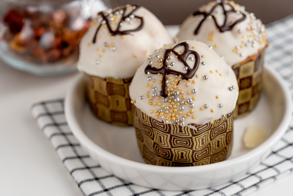 easter cakes in a white plate on the table on a checkered towel with the inscription christ is risen - Кулич царский