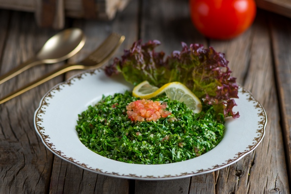 fresh tabouleh salad or tabbouleh served in a dish isolated on wooden background side view - Салат из крапивы с зелёным луком