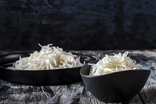 grated daikon in two ceramic plates and chopsticks - Салат из редьки