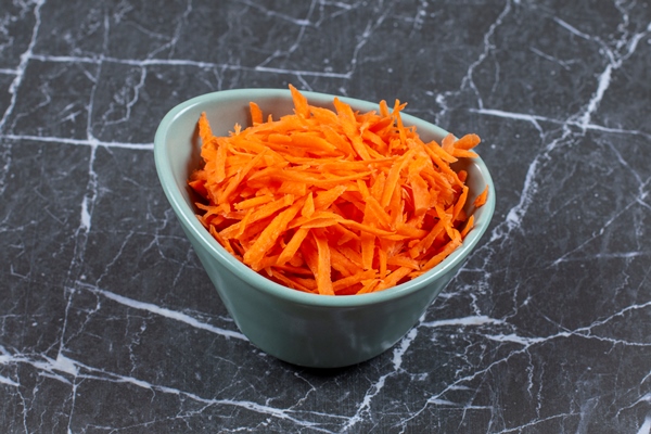 grated fresh carrot in a blue ceramic bowl - Салат из крапивы и одуванчика