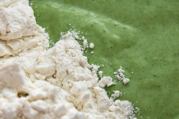 green pancake batter with wheat flour making spinach or green tea matha pancakes close up - Постные капустные блинчики со шпинатом