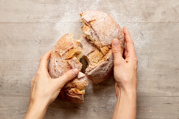 hands breaking a delicious bread - Библия о пище