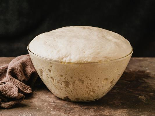 high angle of bowl with growing dough for pizza - Кулич по-польски