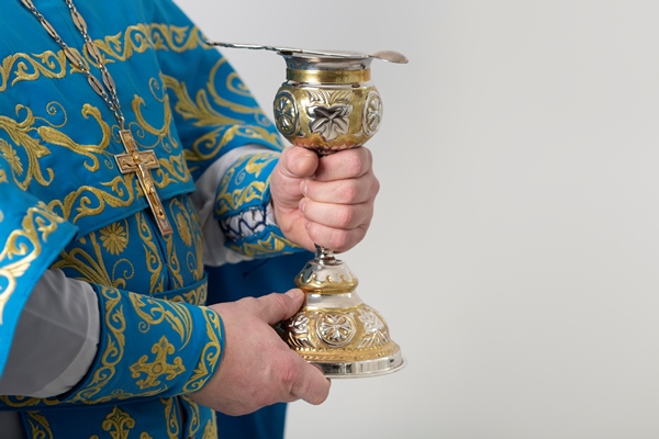 holy communion concept with priest holding cup - Библия о пище