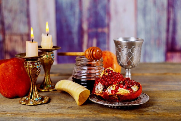 honey apple and pomegranate on wooden table over bokeh background - Библия о пище
