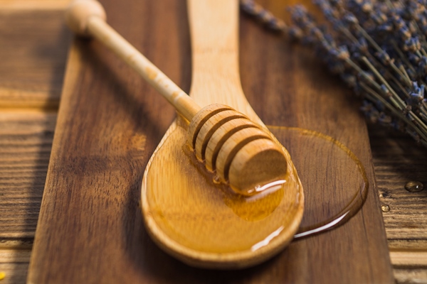 honey dipper on wooden spoon over the chopping board - Постные блины со свёклой и орешками