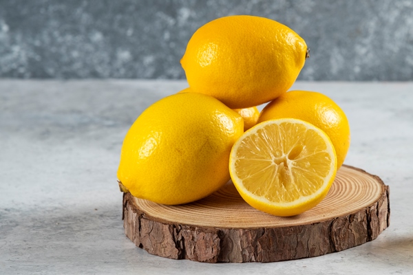 lemon slices in wooden board with a whole lemon on marble background - Постные блинчики с карамельным яблоком