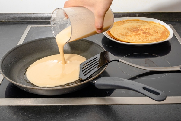 male human hand fill dough for pancake into pan while cooking breakfast for family 1 - Постные блины из миндальной муки