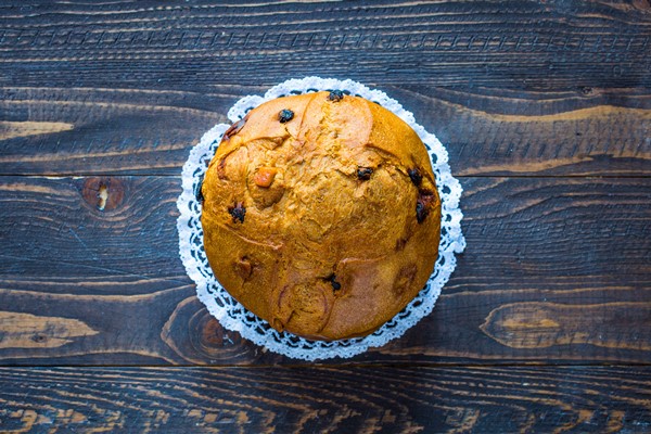 panettone with fruit and christmas decoration on a wooden background - Пасхальный кулич