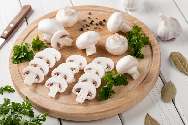 raw champignon mushrooms on cutting board - Диетический куриный суп с гречкой и грибами