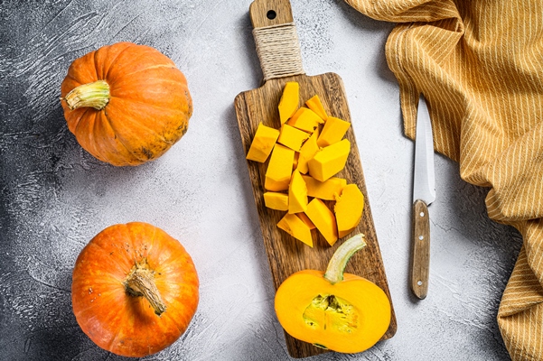 raw pumpkin cubes on a cutting board top view - Пирог из тыквы