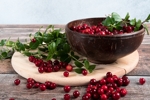 ripe fresh cowberry in wooden bowl on rustic wooden table - Салат из брусники